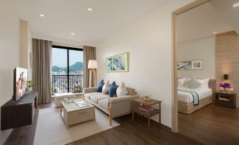 a modern living room with a beige couch , coffee table , and large window overlooking the ocean at Somerset Harbourview Sri Racha