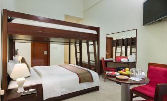 a hotel room with a double bed and a double bed , both made up with white sheets at Ras Al Jinz Turtle Reserve