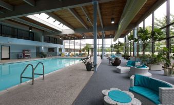 an indoor swimming pool surrounded by lounge chairs , where people are relaxing and enjoying their time at Holiday Inn Clinton - Bridgewater