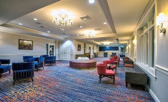 a large room with a carpeted floor and multiple couches arranged in various seating areas at Gettysburg Hotel