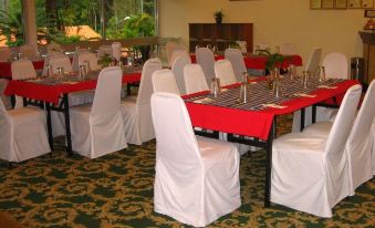 a large room with tables covered in white tablecloths and chairs arranged for a banquet at Shahzan Inn Fraser's Hill