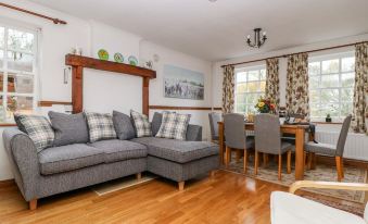 a cozy living room with hardwood floors , a gray sectional sofa , and a dining table at Travelodge Scotch Corner Skeeby