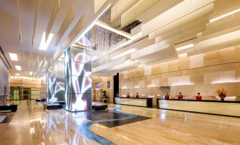 The lobby of the hotel is elegantly decorated with a large chandelier and glass partitions at Nina Hotel Tsuen Wan West