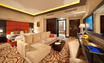 a modern living room with a large white couch , coffee table , and television in the background at Mangrove Hotel