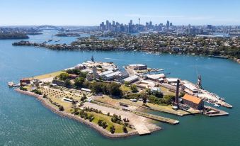 an aerial view of a city with tall buildings and a large body of water at Cockatoo Island Accommodation
