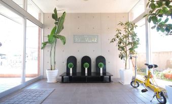 a room with three black benches and three potted plants , creating a cozy and inviting atmosphere at Toyota Village