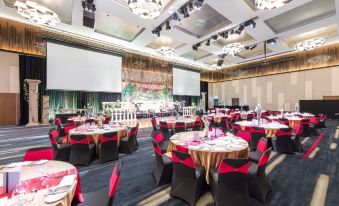 a large banquet hall filled with round tables and chairs , ready for a formal event at Racv Royal Pines Resort Gold Coast