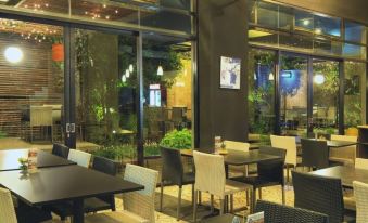 an outdoor dining area with several tables and chairs , creating a pleasant atmosphere for guests at High Livin Apartment Baros