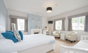 a white bedroom with two beds , one on the left and one on the right side of the room at The Fishbourne