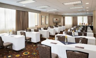 a large conference room with multiple tables and chairs arranged for a meeting or event at Hilton Los Angeles-Culver City, CA