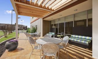a patio area with a dining table and chairs , as well as a couch and chairs at Home2 Suites by Hilton Oxford