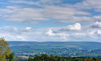 a scenic view of a city nestled in the hills with clouds and blue skies at Home2 Suites by Hilton Dickson City Scranton