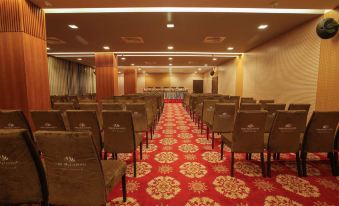 a large conference room with rows of chairs arranged in a semicircle , and a podium at the front at Long Beach Hotel