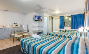 a hotel room with two beds , a tv on the wall , and a dining table at Aspley Carsel Motor Inn