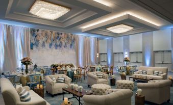 a luxurious banquet hall with multiple couches and chairs arranged for guests to sit and relax at Hilton Los Angeles-Culver City, CA
