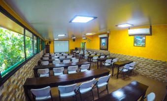 a large conference room with multiple rows of chairs arranged in front of a projector screen at Hotel Estero y Mar