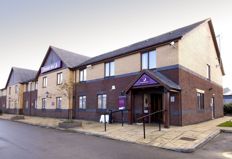 a building with a purple sign on the side and a black awning in front at Premier Inn Blackpool Airport
