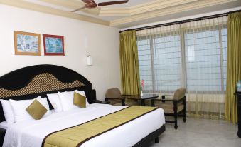 a large bed with a gold and white comforter is in the middle of a room at Hotel Sea View