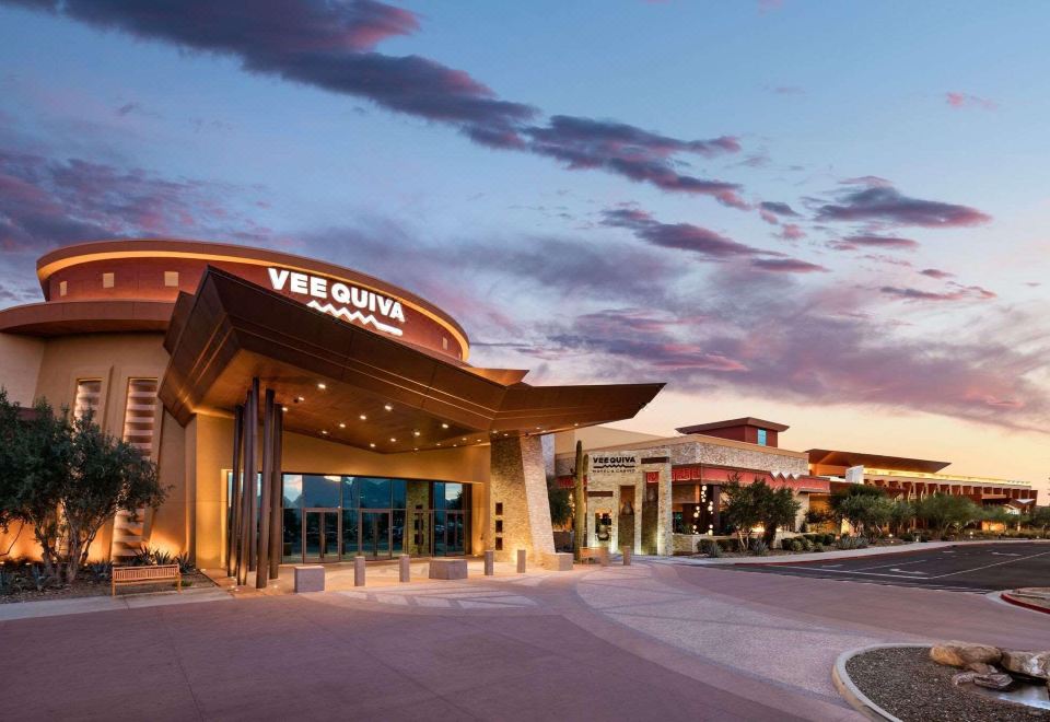 a shopping mall entrance with a large sign above the door , surrounded by a parking lot at Gila River Resorts & Casinos – Vee Quiva