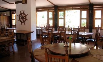 a large , open dining room with wooden tables and chairs arranged around a central table at Country Inn Masindi