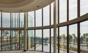 a large , empty room with a circular floor and large windows overlooking a body of water at Hyatt Regency Long Beach