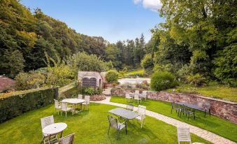 a lush green lawn with a picnic table and chairs set up for outdoor dining at Castle of Comfort Hotel