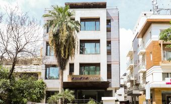 a three - story building with a large window , surrounded by trees and other buildings in the background at Amara Hotel