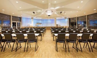 a large conference room with rows of chairs arranged in a semicircle , ready for a meeting at Scandic Ishavshotel