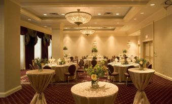 a large , well - decorated banquet hall with multiple tables set for a formal event , adorned with elegant decorations at The Saint Paul Hotel