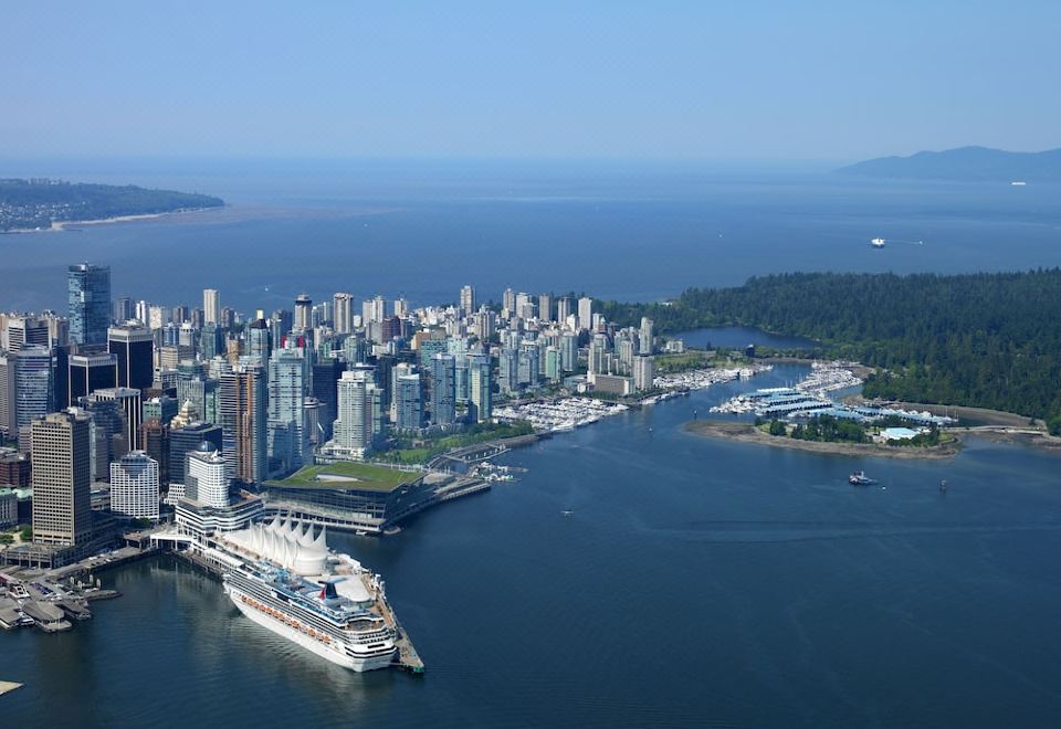 an aerial view of a large city with tall buildings and a docked cruise ship at Pan Pacific Vancouver