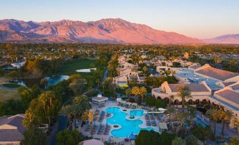 an aerial view of a resort with multiple swimming pools , mountains in the background , and palm trees at The Westin Rancho Mirage Golf Resort & Spa