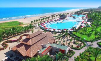 aerial view of a large resort with multiple swimming pools , palm trees , and a beach in the background at Royal Decameron Punta SAL - All Inclusive