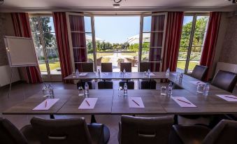 a large dining room with multiple tables and chairs arranged for a meeting or event at La Ramade - Teritoria