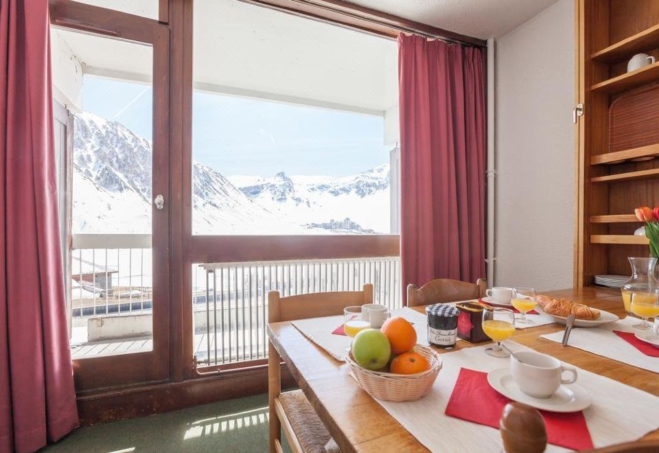 a dining table set with a variety of food items , including fruits , vegetables , and bowls at Langley Hotel Tignes 2100