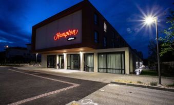 "a large hotel building with a red sign that says "" hampton inn "" in front of it" at Hampton by Hilton Toulouse Airport