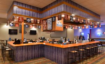 a restaurant with a bar area , where several people are seated and enjoying their meals at Holiday Inn ST. Petersburg N- Clearwater