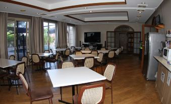 a large dining room with multiple tables and chairs arranged for a group of people to enjoy a meal together at Sleepy Hill Motor Inn