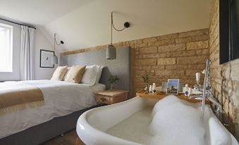 a modern bedroom with a large bed and a bathtub in the middle of the room at Wild Thyme & Honey
