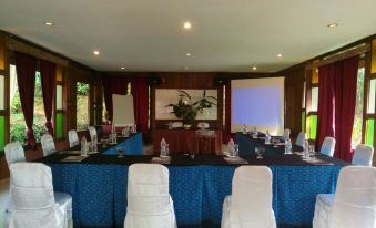 a conference room set up for a meeting , with chairs arranged in rows and a projector on the wall at Imah Seniman