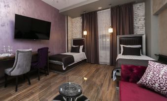 A hotel or motel offers a room with a bed, TV, and table in the living area at Mia Milano Hotel