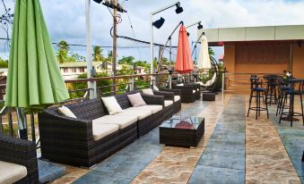 a rooftop patio with several couches and chairs arranged for people to lounge and socialize at Leisure Inn