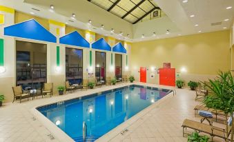 an indoor swimming pool surrounded by chairs and tables , providing a relaxing atmosphere for guests at Crowne Plaza Englewood, an IHG Hotel