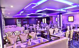 a large dining room with numerous tables and chairs , some of which are covered in white tablecloths at The Riverside Inn