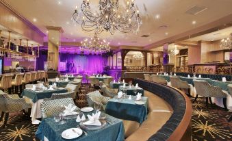 a large dining room with multiple tables and chairs arranged for a group of people to enjoy a meal together at Gold Reef City Theme Park Hotel