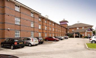 "a large brick building with cars parked in front of it and a sign that says "" comfort inn ""." at Premier Inn Derby East