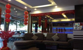 a living room with a couch , dining table , chairs , and red lanterns hanging from the ceiling at Royal Hotel