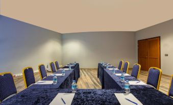 a conference room set up for a meeting , with several chairs arranged in a semicircle around a long table at Aquaworld Belek