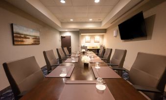 a conference room with a long wooden table and several chairs arranged for a meeting at Courtyard Philadelphia Springfield