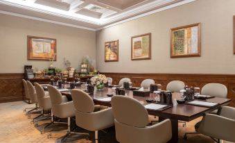 a conference room with a long wooden table , several chairs , and framed pictures on the wall at Anantara Al Jabal Al Akhdar Resort