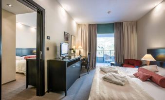 a modern hotel room with a bed , desk , and tv , as well as a balcony view at Admiral Grand Hotel
